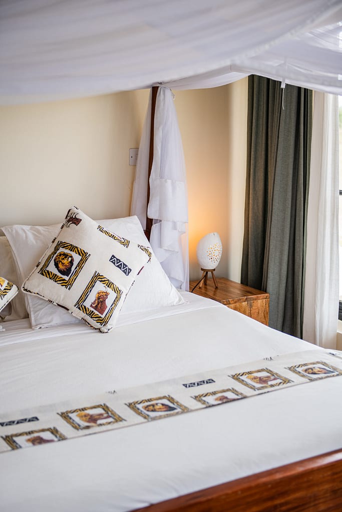 Luxurious bedroom with neatly made bed and colorful cushions at Kobe Mara.