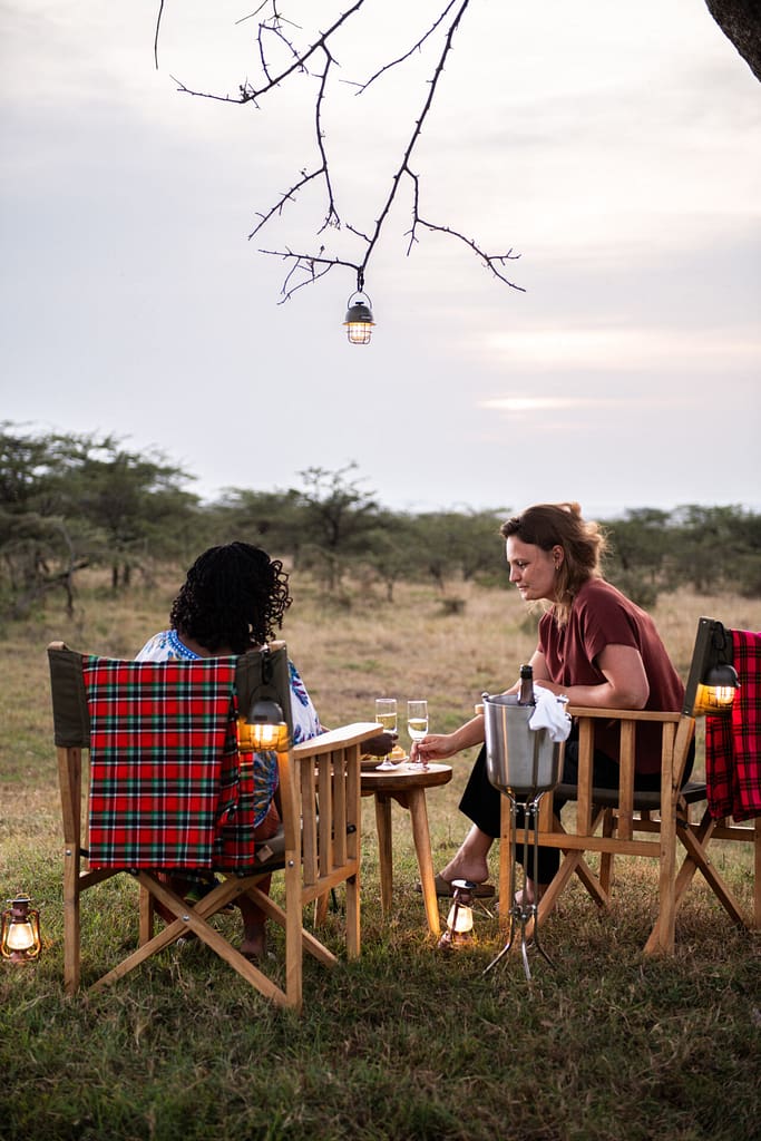 Outdoor dining setup under a tree at Kobe Mara safari camp.